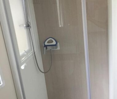 Cabine de douche avec pommeau et paroi vitrée dans le mobil-home La Baume 515