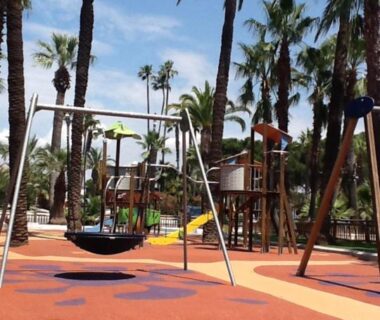 Aire de jeux ombragée avec balançoires et toboggans au camping La Baume 515