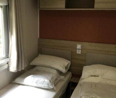 Chambre avec deux lits et fenêtre au camping La Baume 515
