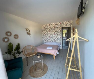 Chambre avec lit double et coin salon à La Buissonnière Lodges