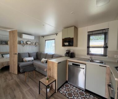 Intérieur avec salon et kitchenette dans le mobil-home La Cabane