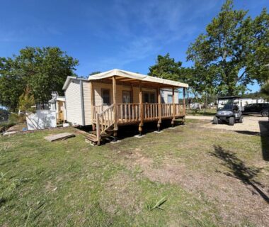 Extérieur mobil home sur pelouse avec terrasse du camping La Cabane
