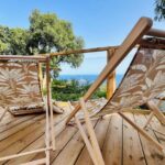 Terrasse en bois avec chaises longues et vue mer à La Cabane de Bob