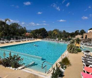 Piscine extérieure avec transats et solarium au camping La Cabane de Bob