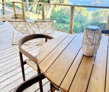 Terrasse en bois avec table et chaises et vue sur la mer à La Cabane de Bob