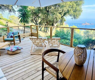 Terrasse en bois avec fauteuils et vue sur la mer à La Cabane de Bob à Saint-Raphaël