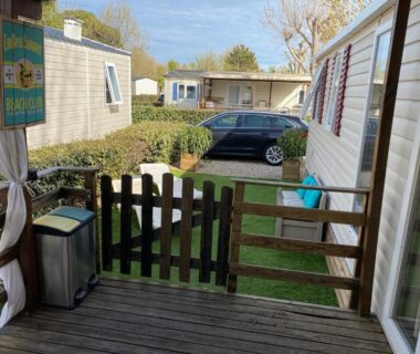 Terrasse en bois avec petit portail et voiture au mobilhome La Carabasse 4 étoiles 6 personnes