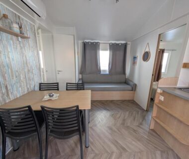 Intérieur mobil home avec coin repas banquette et kitchenette dans le logement La Carabasse Les Mazets 101