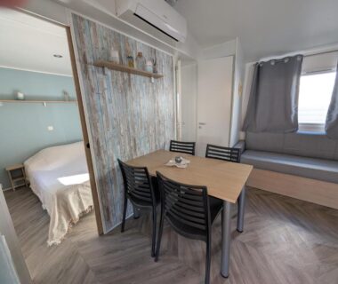 Séjour avec table à manger banquette et chambre ouverte dans l'hébergement La Carabasse Les Mazets 101