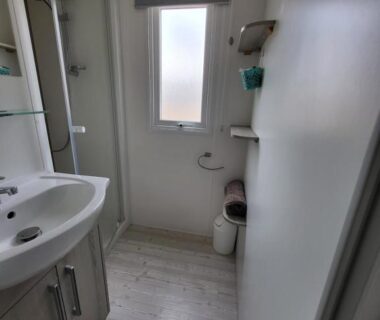 Salle de bains avec douche et lavabo dans le logement Te Mahana
