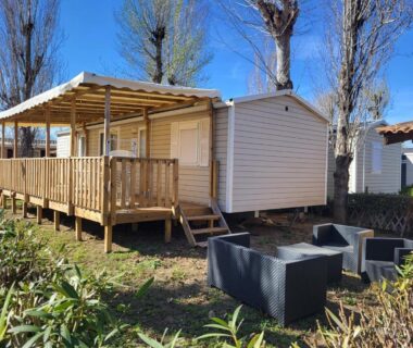 Terrasse en bois et salon extérieur devant mobil-home du camping La Carabasse-Vias Te Mahana