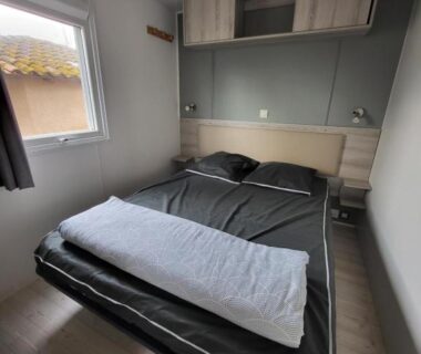 Chambre avec lit double et fenêtre dans le mobil-home La Carabasse-Vias Te Mahana