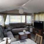 Séjour avec canapés et télévision dans le mobil-home La Chanterie Agréable Mobil-Home Résidentiel Normand