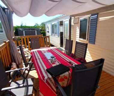 Terrasse ombragée avec table et chaises au mobil-home La Chanterie Agréable Mobil-Home Résidentiel Normand