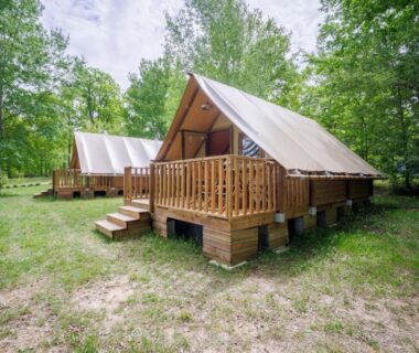 Clairière boisée avec tentes lodges sur pilotis à La Clairière écocamping en vallée de la Dordogne