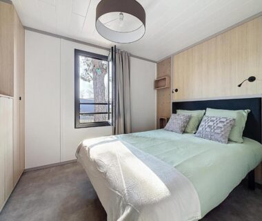Chambre avec lit double et fenêtre au camping La Criste Marine