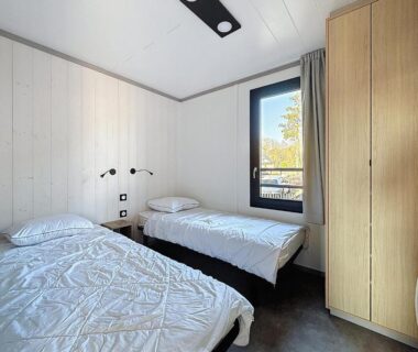 Chambre avec deux lits simples et armoire dans le logement du camping La Criste Marine
