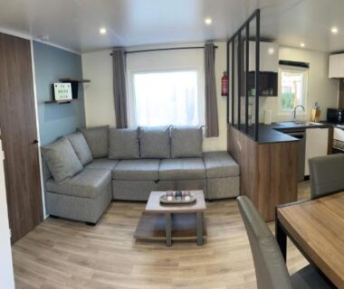 Salon avec canapé d'angle et kitchenette dans le logement La Dolce Vita