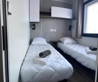 Chambre avec deux lits simples et serviettes au camping La Dolce Vita