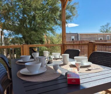 Terrasse extérieure avec table dressée pour petit déjeuner au mobil home La Dolce Vita Méditerranéenne Camping Les Dunes
