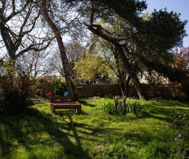 Jardin ombragé avec banc et pelouse au camping La Dorépontaise ROULOTTE