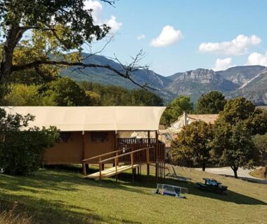 Terrasse herbeuse avec tente lodge et montagnes en arrière plan à La Ferme de Clareau Glamp'In Lodge Nature