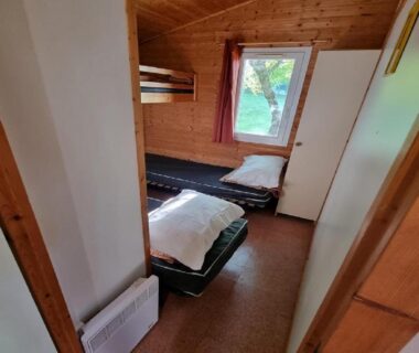 Intérieur de chalet avec deux lits simples du camping La Forêt Enchantée