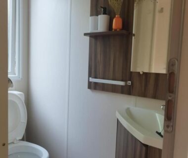Salle de bain avec WC lavabo miroir et étagère de La Margotine Mobil Home Cosy Plage et Dunes Camiers
