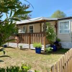Devant le mobil home avec terrasse et jardinet dans le camping La Paillote de Claire