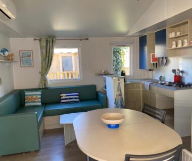 Séjour avec canapé et kitchenette dans le mobil-home La Parenthèse