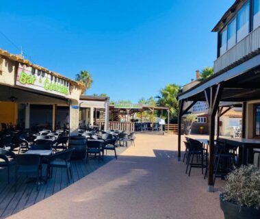 Terrasse extérieure avec tables et chaises sous ciel bleu à La Parenthèse