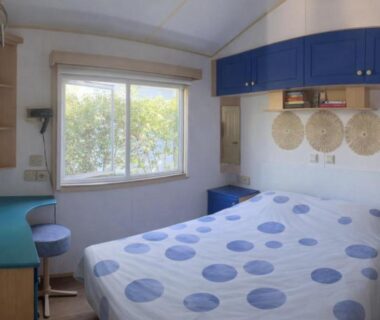 Chambre avec lit double et rangements dans La Pinède Ensoleillée au Camping La Dune Blanche