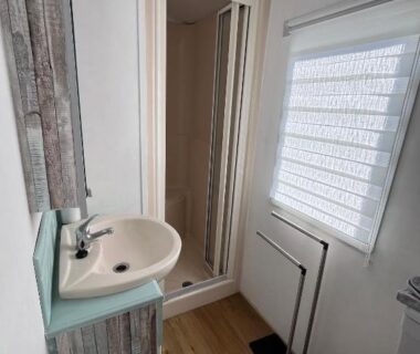 Salle d'eau avec cabine de douche et lavabo dans le logement La Pinède Ensoleillée au Camping La Dune Blanche