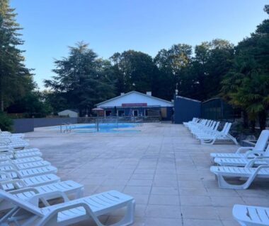 Bord de piscine avec transats à La Pinède Ensoleillée au Camping La Dune Blanche