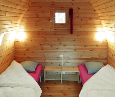 Intérieur de pod en bois avec deux lits dans La Rossignolerie – POD Cabanes des châteaux