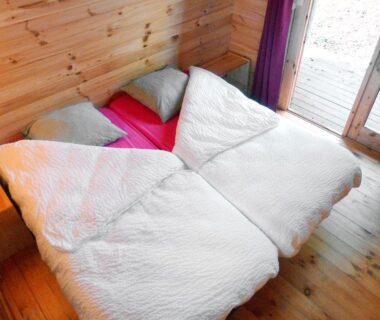 Chambre en bois avec deux lits simples dans La Rossignolerie POD Cabanes des châteaux