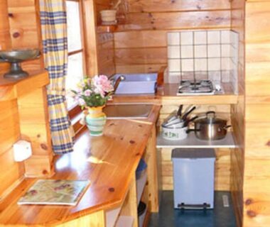 Intérieur coin cuisine en bois avec cuisinière dans l'hébergement La Valière