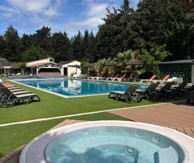Piscine extérieure avec jacuzzi et transats au camping La Vallée De Taradeau
