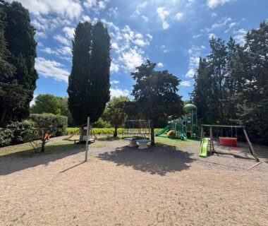 Aire de jeux ombragée avec balançoires au camping La Vallée De Taradeau