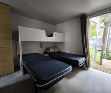 Chambre avec lits simples et porte-fenêtre sur terrasse du La Yole Mobil-home bord de mer et grand espace aquatique