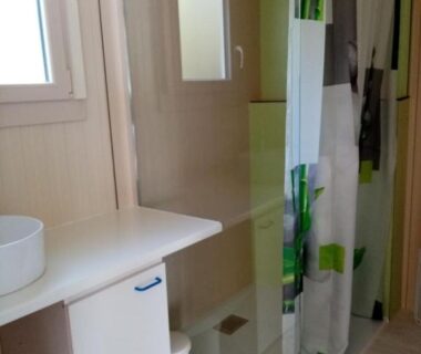 Salle de bain avec douche et lavabo dans le logement La belle étoile