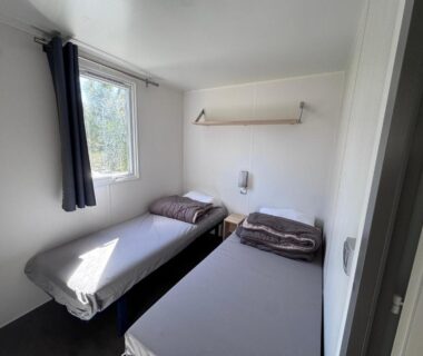 Chambre avec deux lits simples et fenêtre dans La cabane de Lise