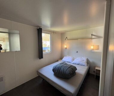 Chambre avec lit double lampes et fenêtre dans la cabane de Lise