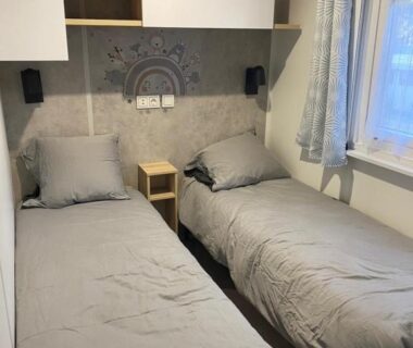 Chambre avec deux lits simples et fenêtre dans la cabane des pins