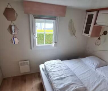 Chambre avec lit double et fenêtre donnant sur extérieur verdoyant à La casa du clos