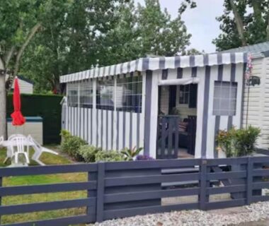 Terrasse et jardin avec salon de jardin et parasol devant le mobil-home de La casa du clos