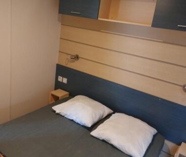 Chambre avec lit double et rangements dans le logement La pépite Rose d’Europapark