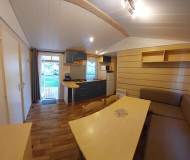 Intérieur de mobil home avec coin cuisine et banquette dans La pépite Rose d'Europapark