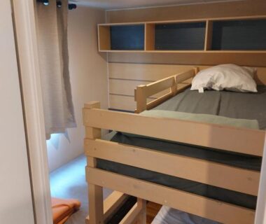 Chambre avec lits superposés et petit hublot dans La pépite Rose d’Europapark
