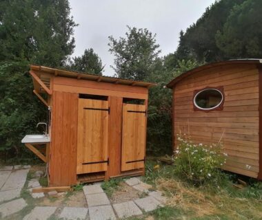 Jardin avec cabane en bois et roulotte à La roulotte aux Nuits Insolites d'Argoumbat
